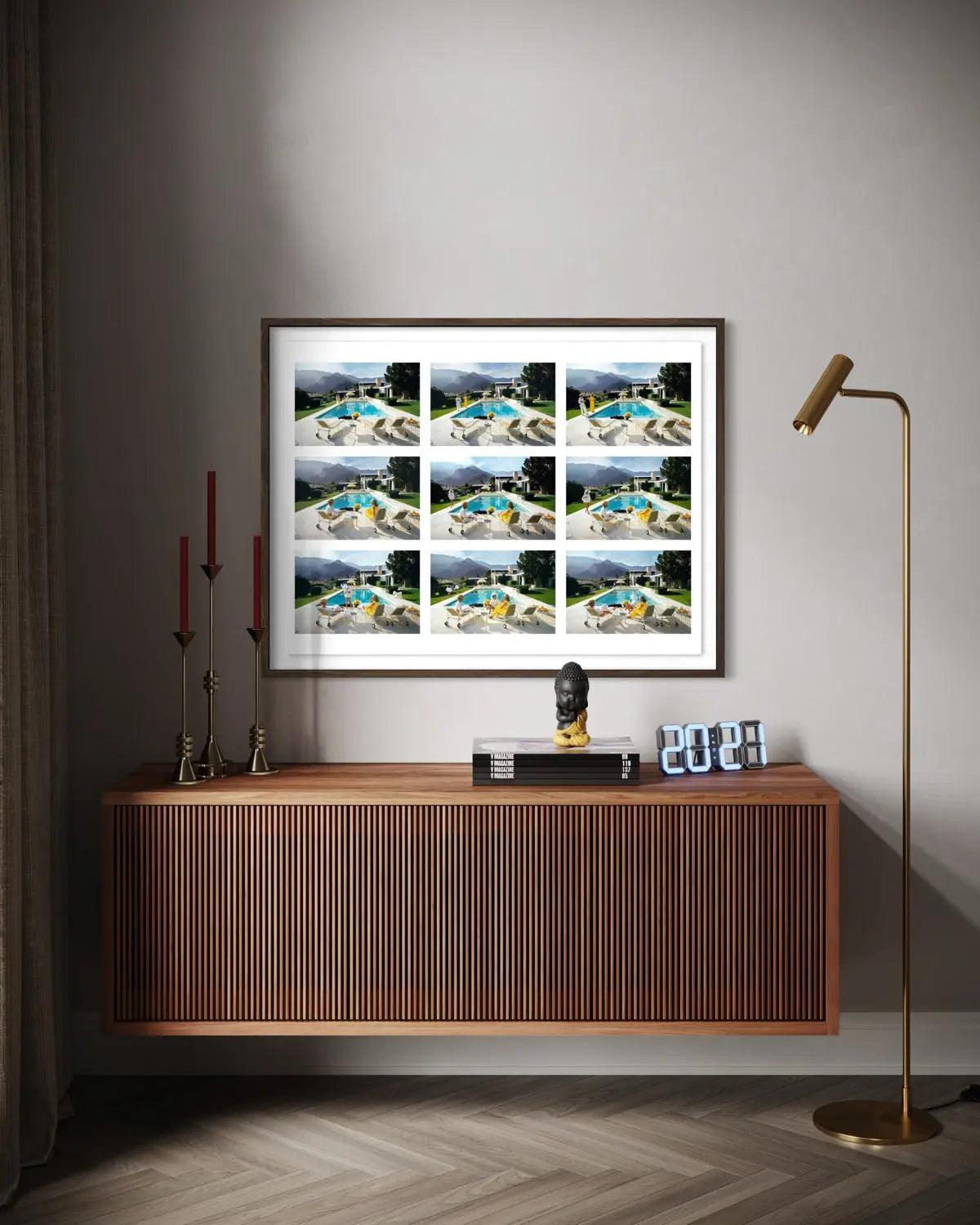 A framed wall art print showing a 3x3 grid of architectural renderings or scenes, displayed above a wooden console in a styled interior with a floor lamp, candles, and decor. The Picturalist Wall Art and Photography for Designed Interiors. Slim Aarons Collection, Poolside. Getty Images Gallery.