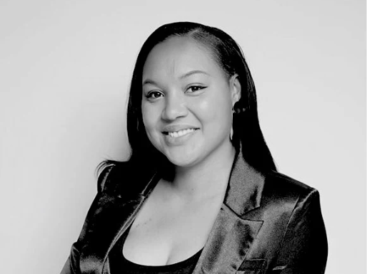 Black and white portrait of a woman wearing a satin jacket against a plain background