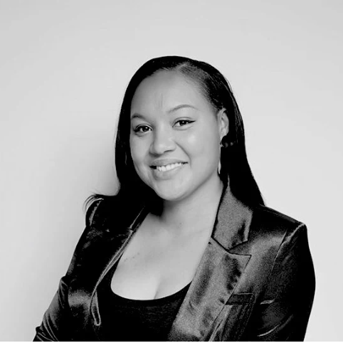 Black and white portrait of a woman wearing a satin jacket against a plain background
