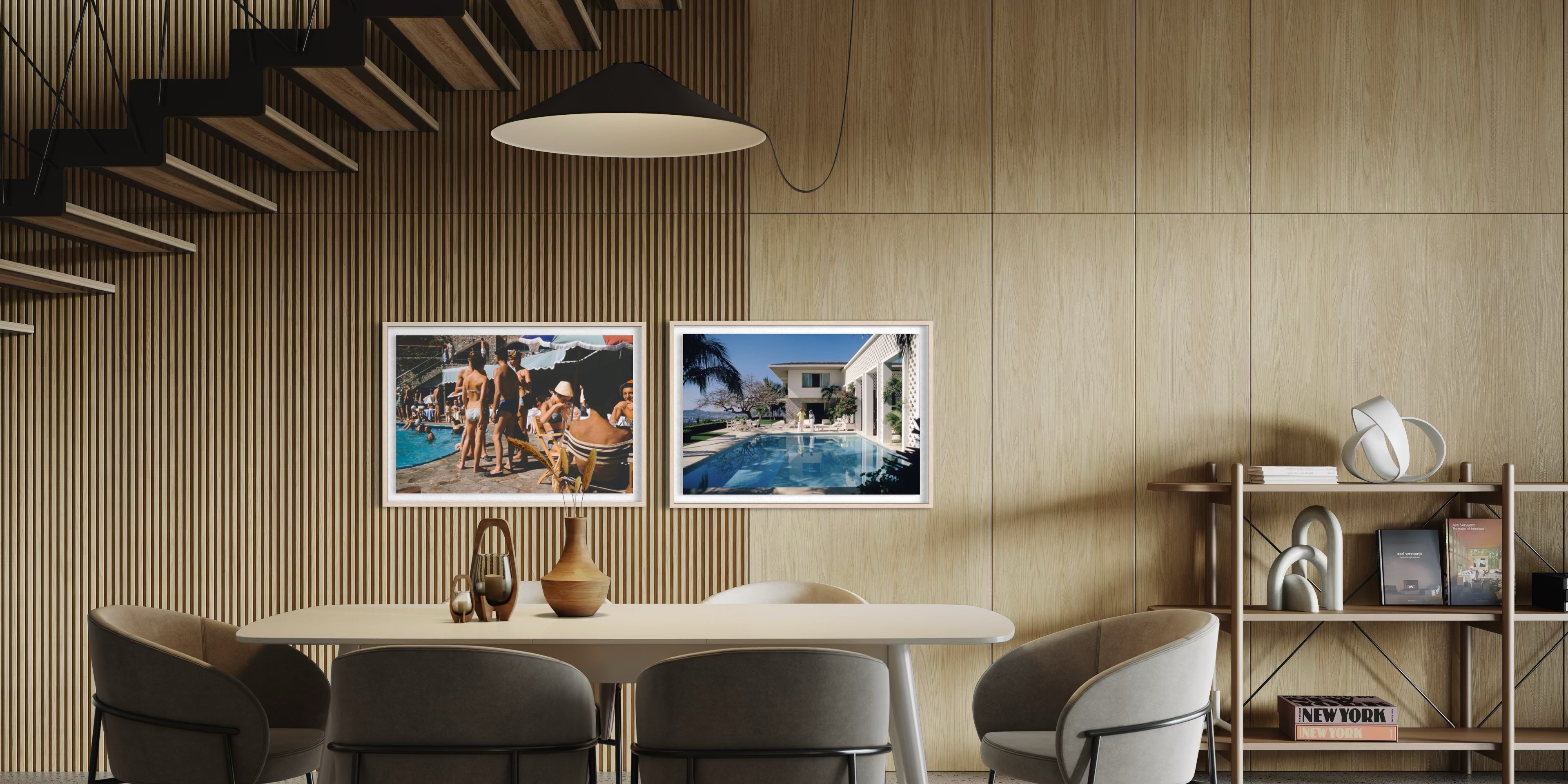 Two framed art prints depicting poolside scenes, displayed side-by-side on a light wood-paneled wall in a modern dining room setting. The Picturalist Wall Art and Photography for Designed Interiors. Slim Aarons Collection, Poolside. Getty Images Gallery.