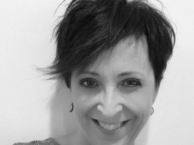 Black and white photo of a person with short hair against a plain background