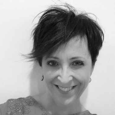 Black and white photo of a person with short hair against a plain background