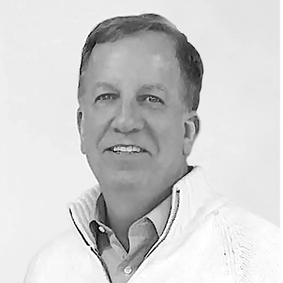 Black and white photo of a man wearing a white sweater with a logo on a light gray background