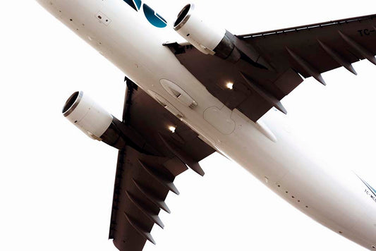 Close-up of an airplane wing with engines on a white background