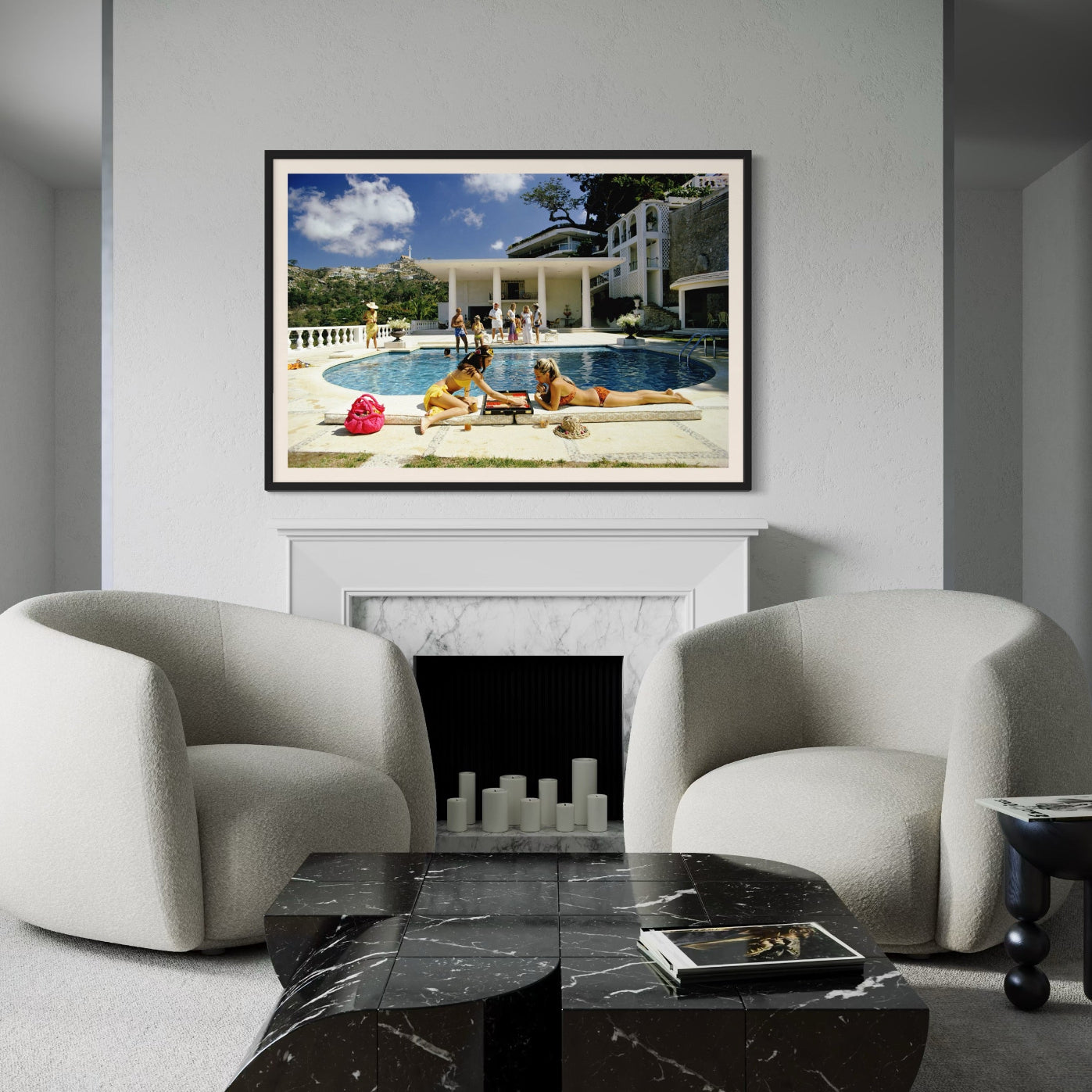 Living room with two armchairs, a coffee table, and a framed picture of people by a pool.