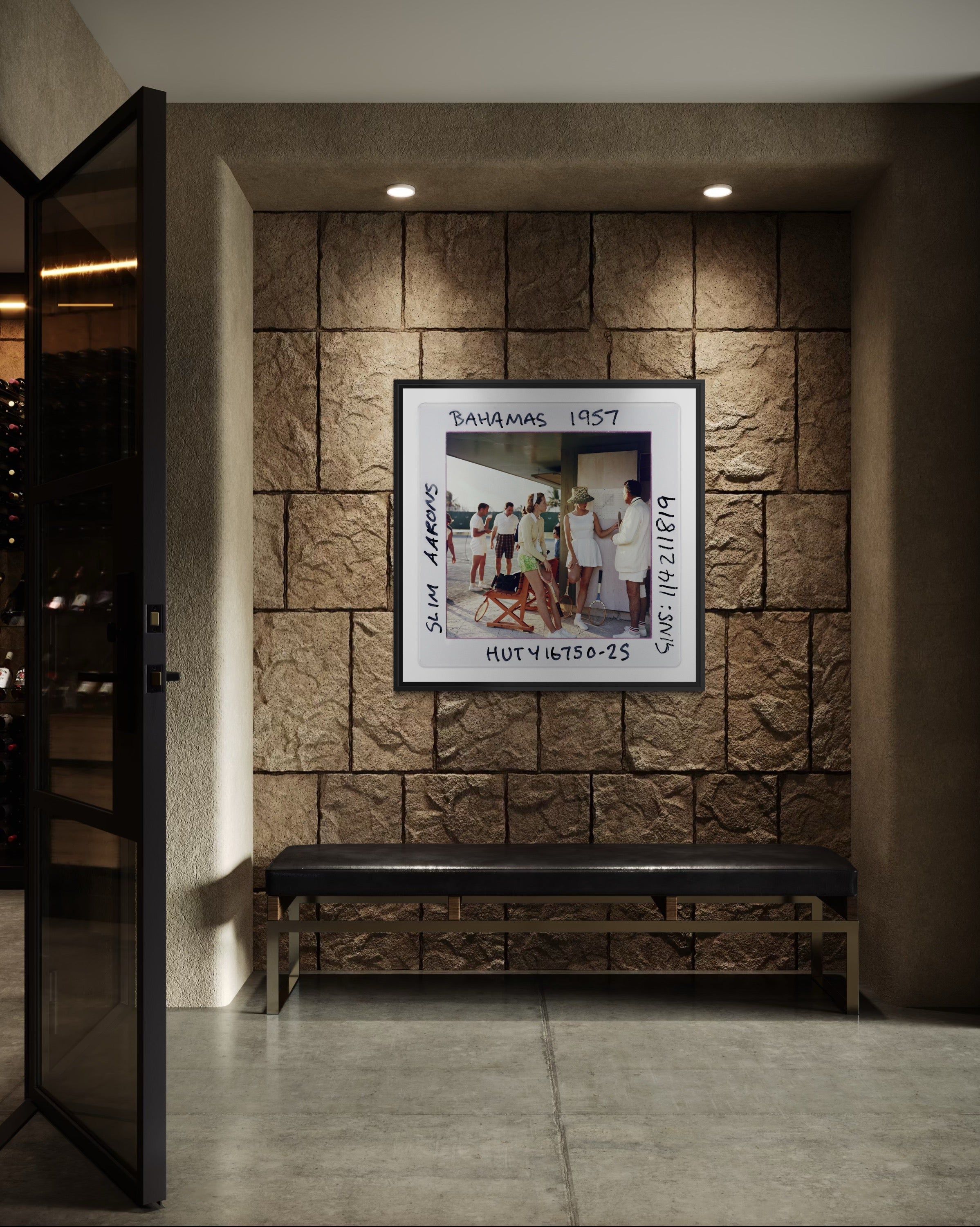 Framed photograph on a stone wall with a bench below