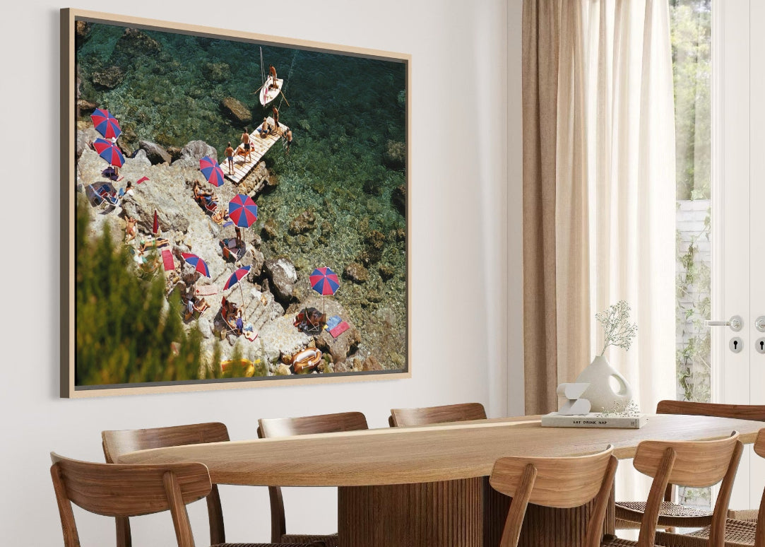 Dining room with a large framed artwork on the wall above a wooden table and chairs.