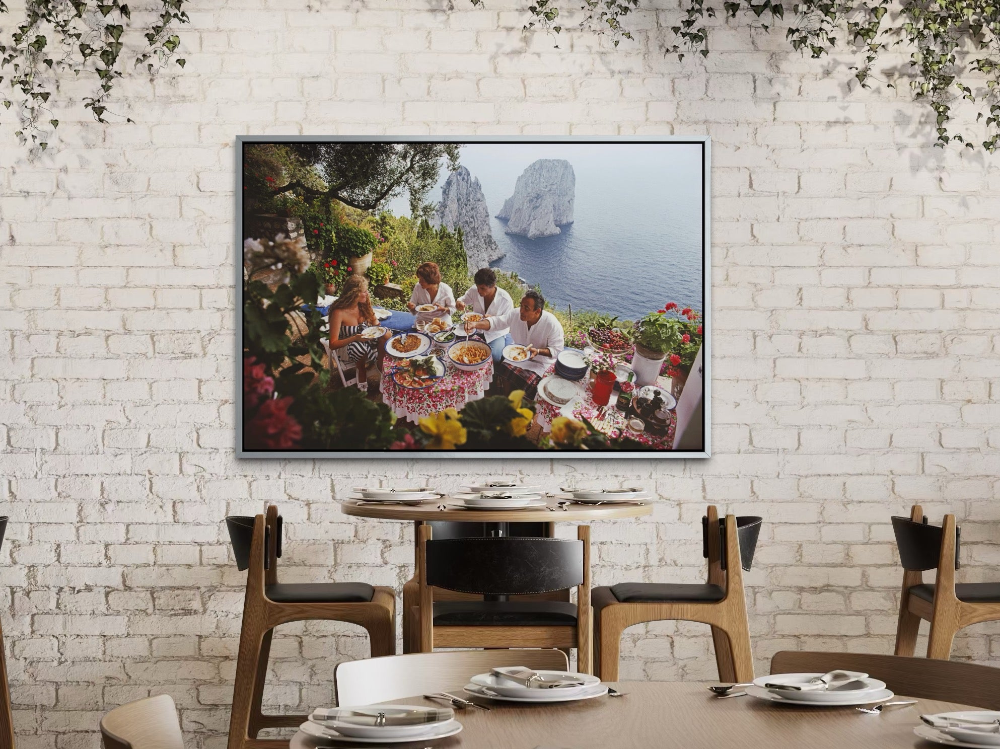 Dining area with a TV displaying an outdoor scene on a white brick wall.
