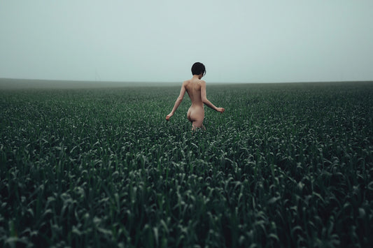 Walking in a Meadow by Igor Ustynsky — fine art photograph of a figure walking through a green field