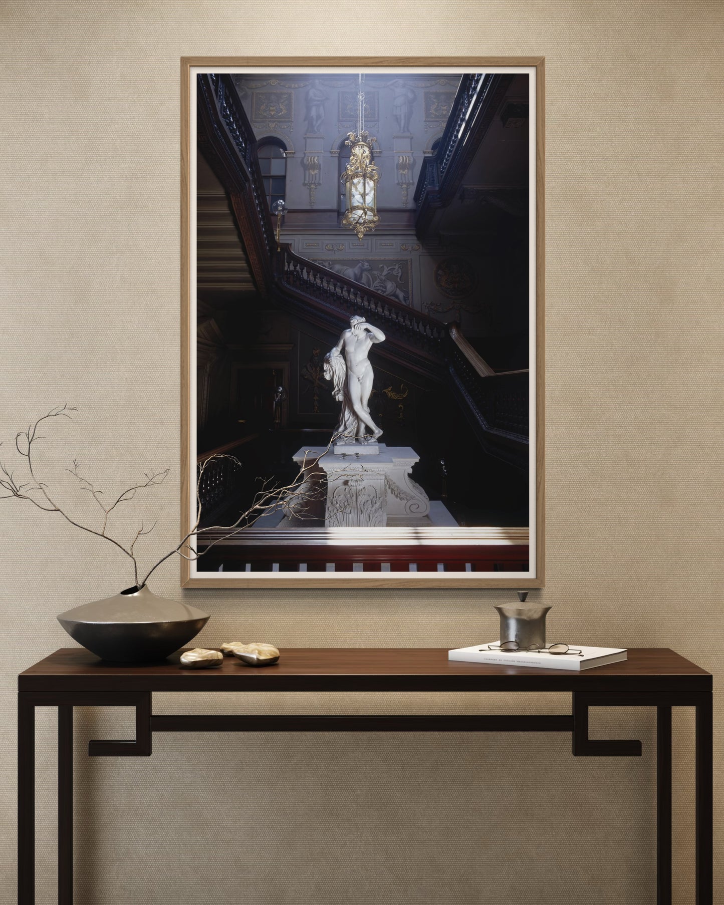 Framed artwork of a classical statue on a wall above a console table with decorative items.