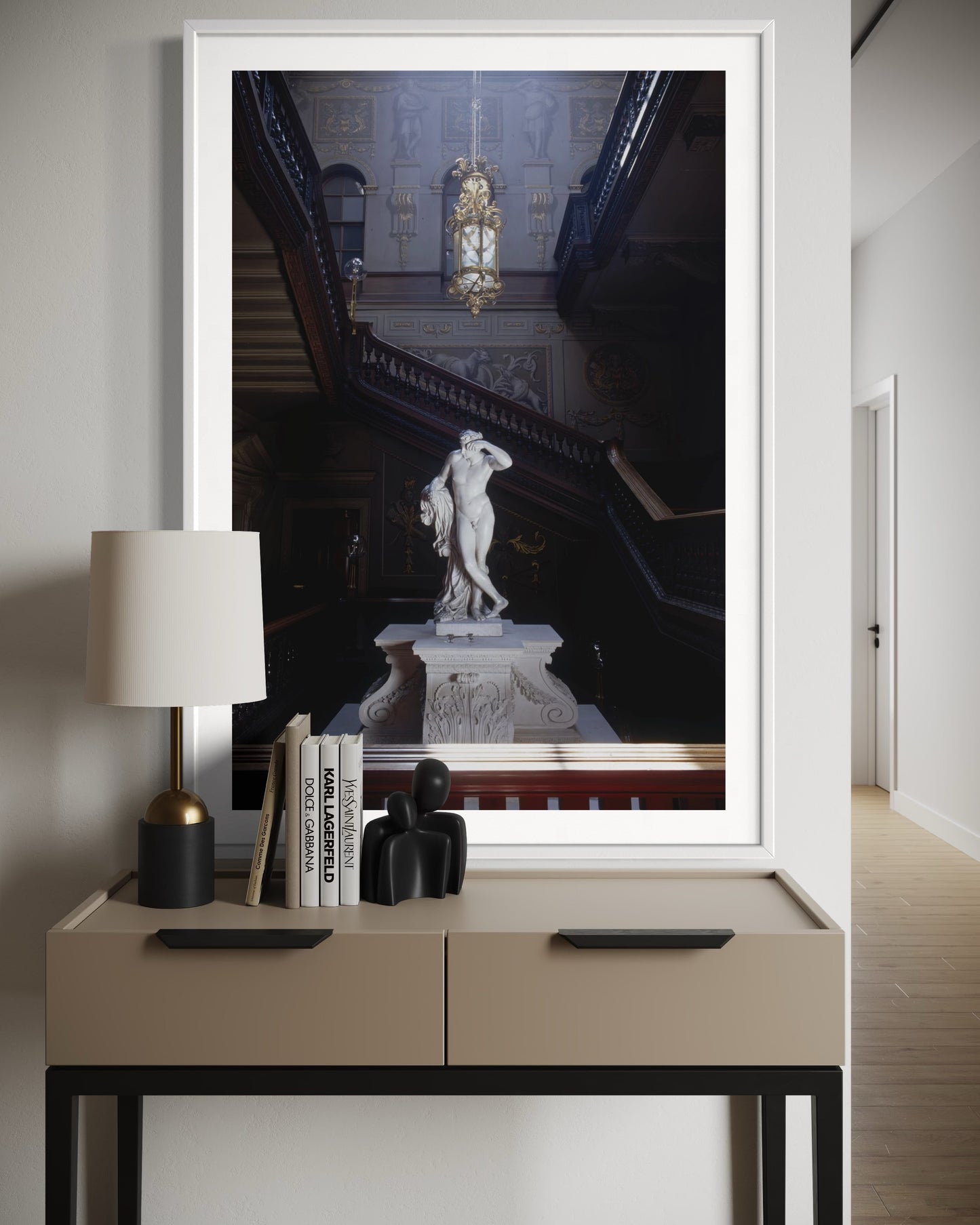 Framed artwork of a classical statue on a wall above a console table with decor items.