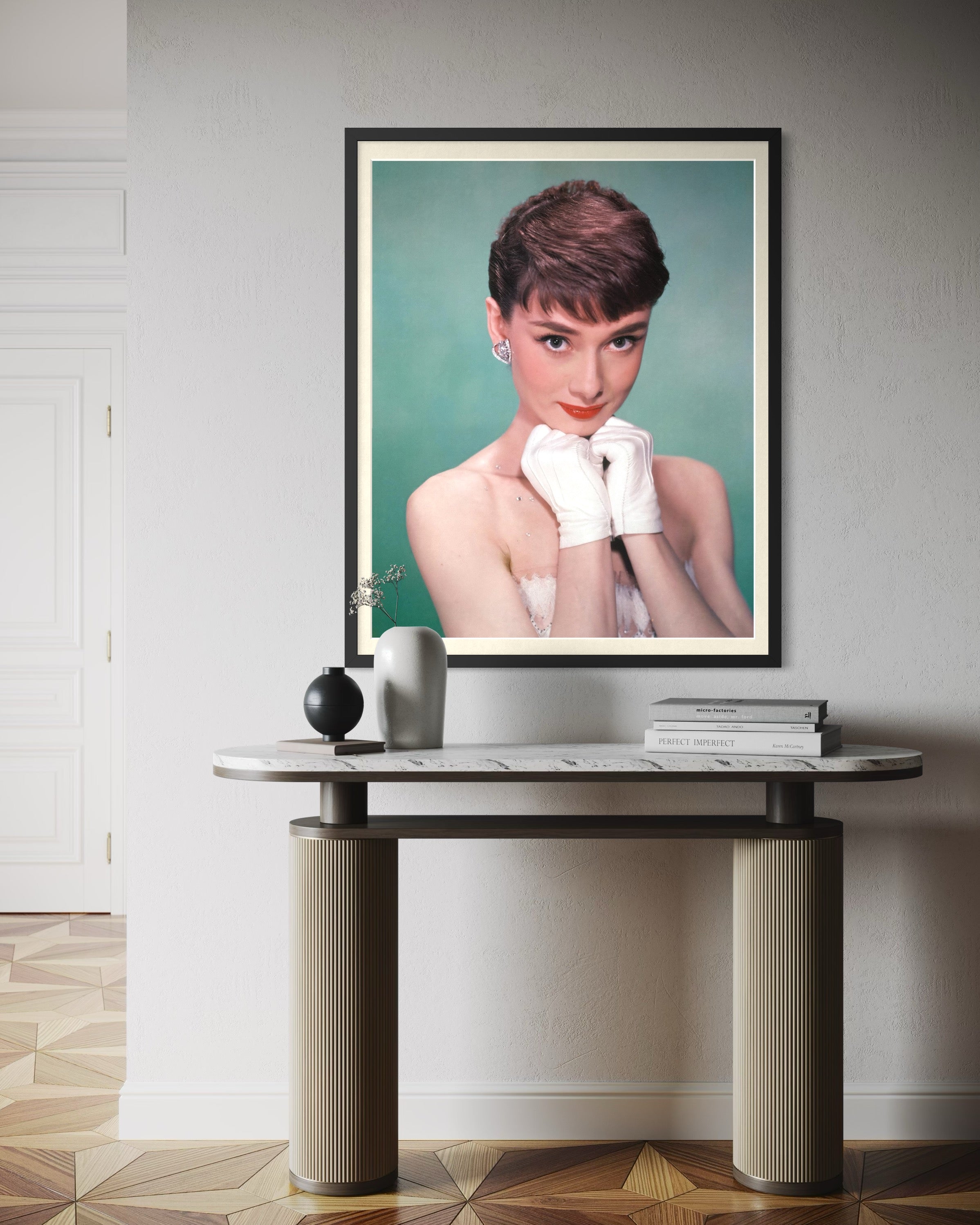 Framed portrait of a woman on a wall above a table.