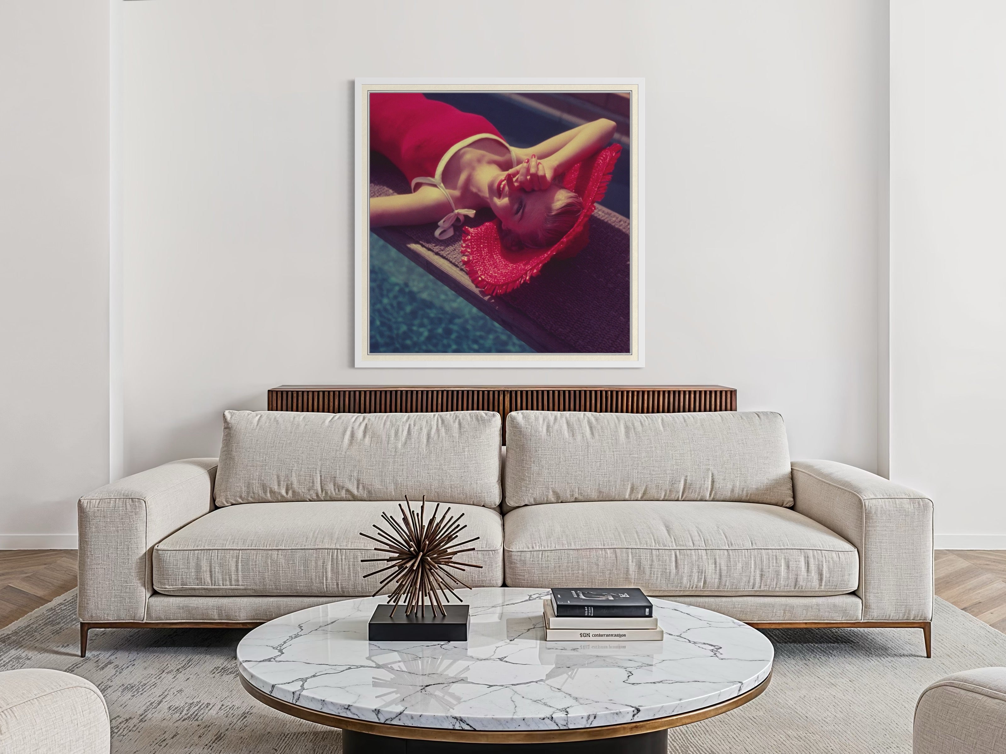 Modern living room with a beige sofa, marble coffee table, and framed artwork on the wall.