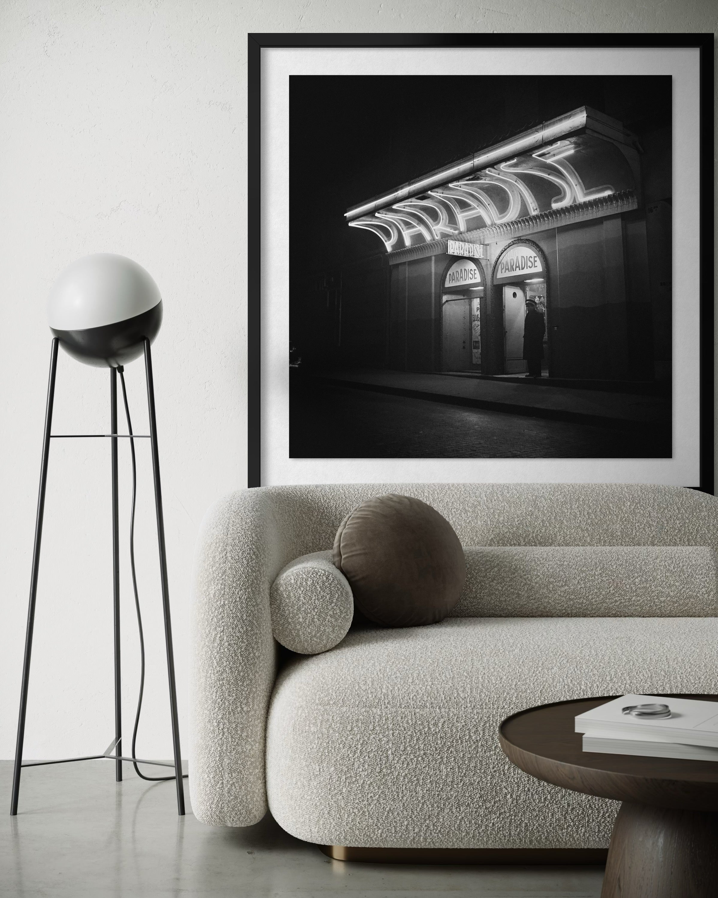 Framed black and white photograph of a building with 'Paradise' sign above a modern living room.
