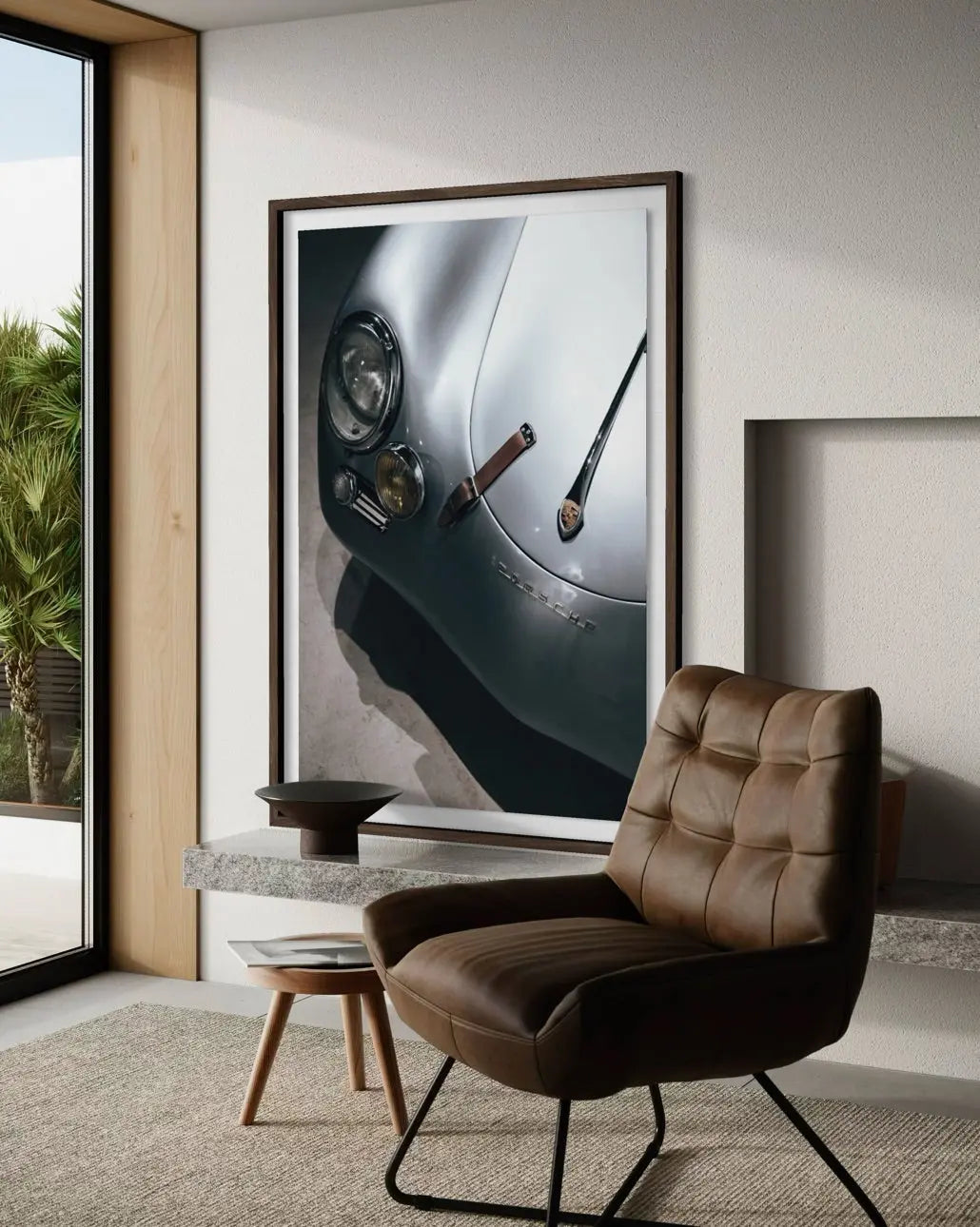A large framed wall art print depicting a close-up of a silver car headlight and dashboard is displayed in a modern living room setting above a brown leather armchair.