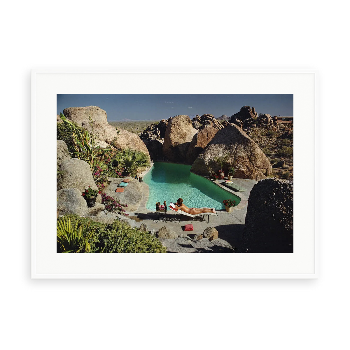 Illustrative matte-white framed preview with white inner border of Sunbathing In Arizona by Slim Aarons. Proportions vary by size.