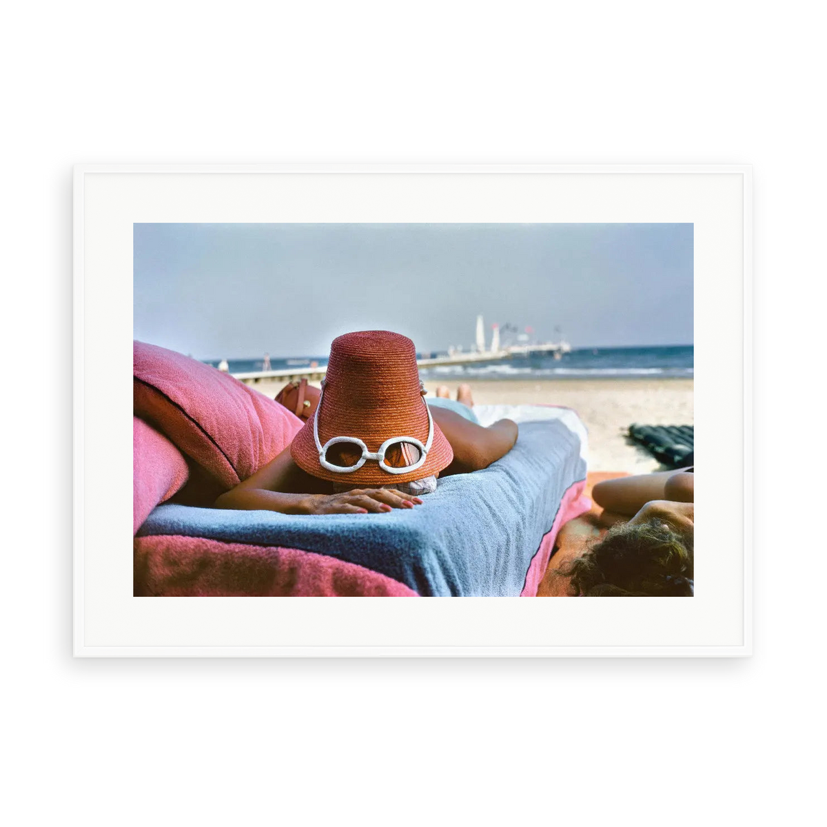 Illustrative matte-white framed preview with white inner border of Sunbathing In Venice by Slim Aarons. Proportions vary by size.