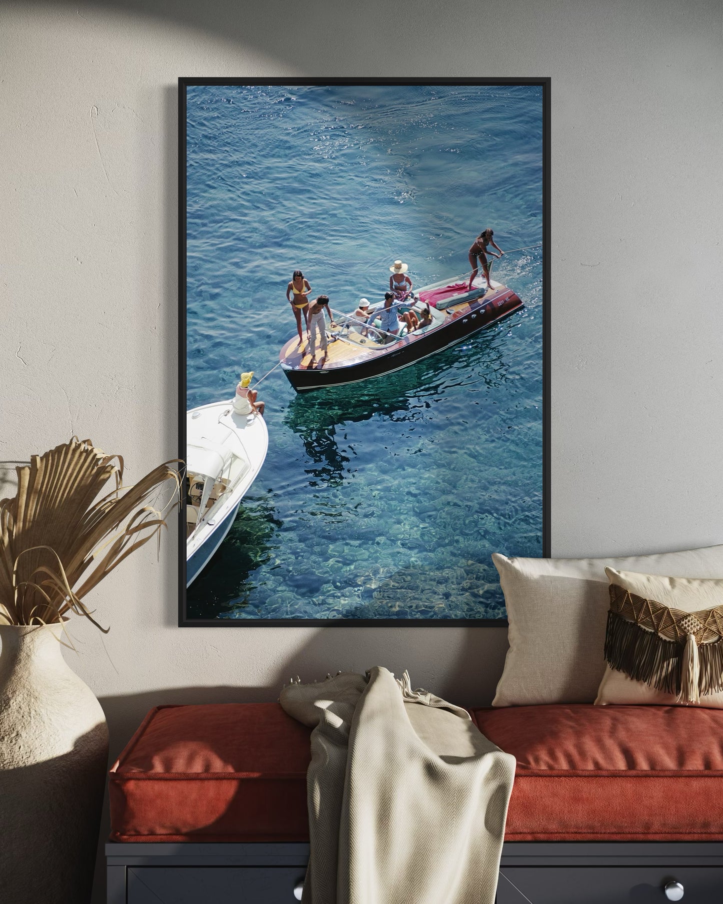 Framed photograph of people on a boat in the water, hanging on a wall above a sofa.