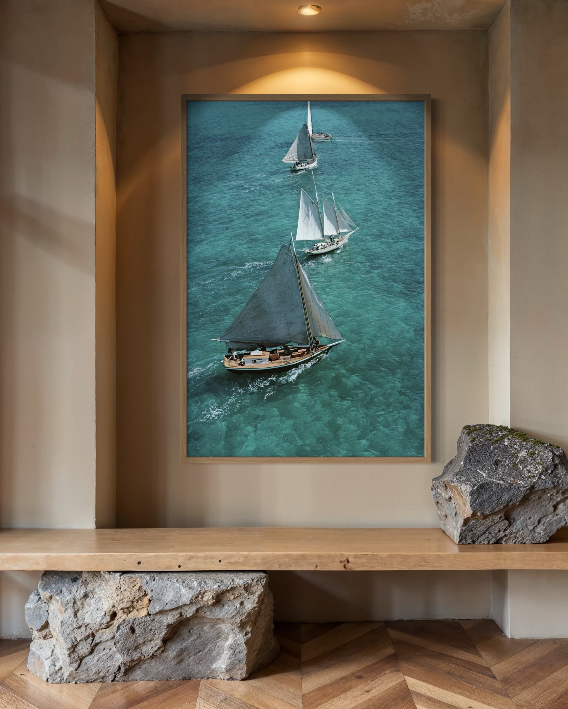 Framed artwork of sailboats on a wall above a wooden shelf.