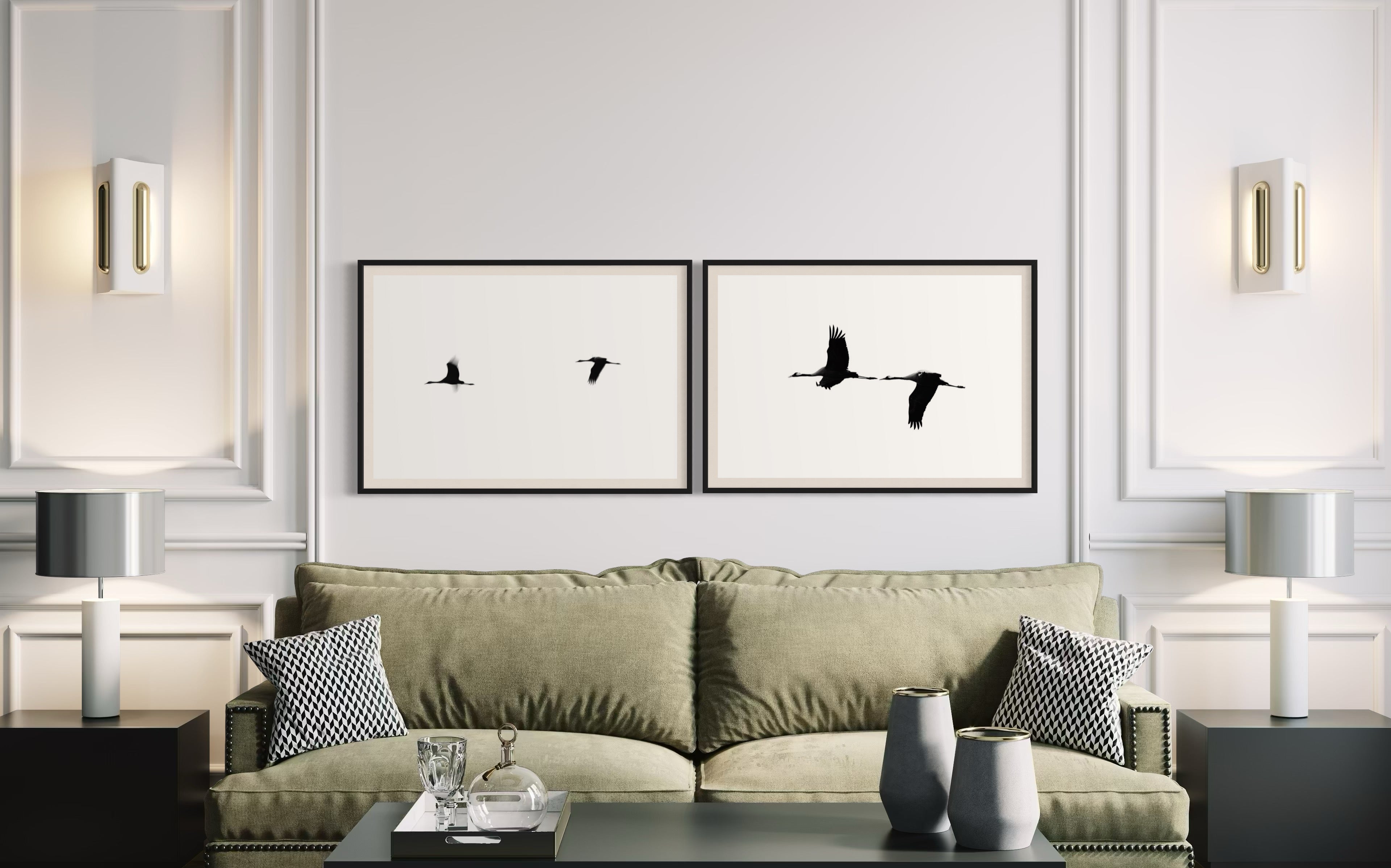 Living room with a green sofa, framed artwork of birds, and decorative items.