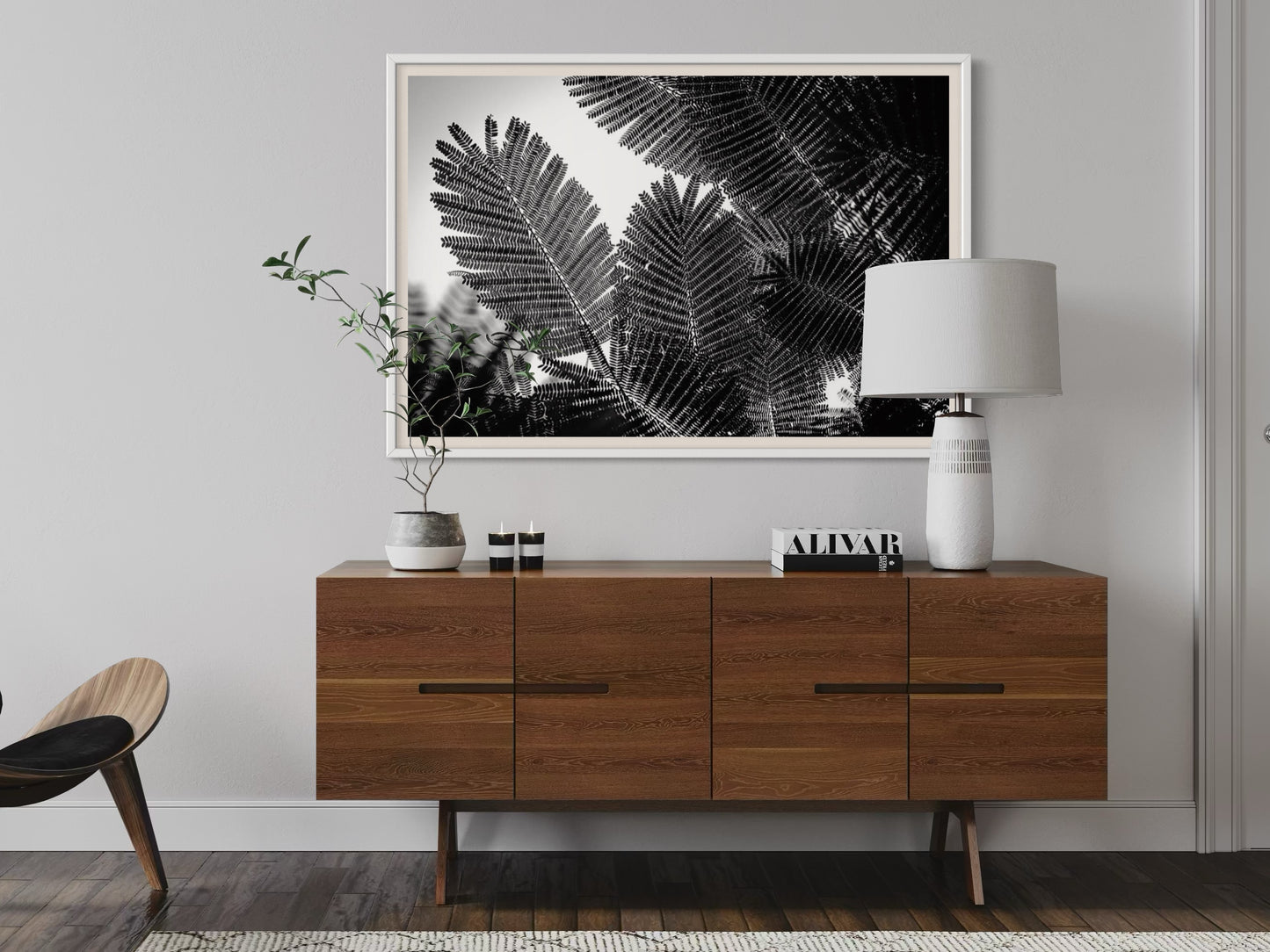 Modern living room with wooden sideboard, lamp, and framed artwork on the wall.
