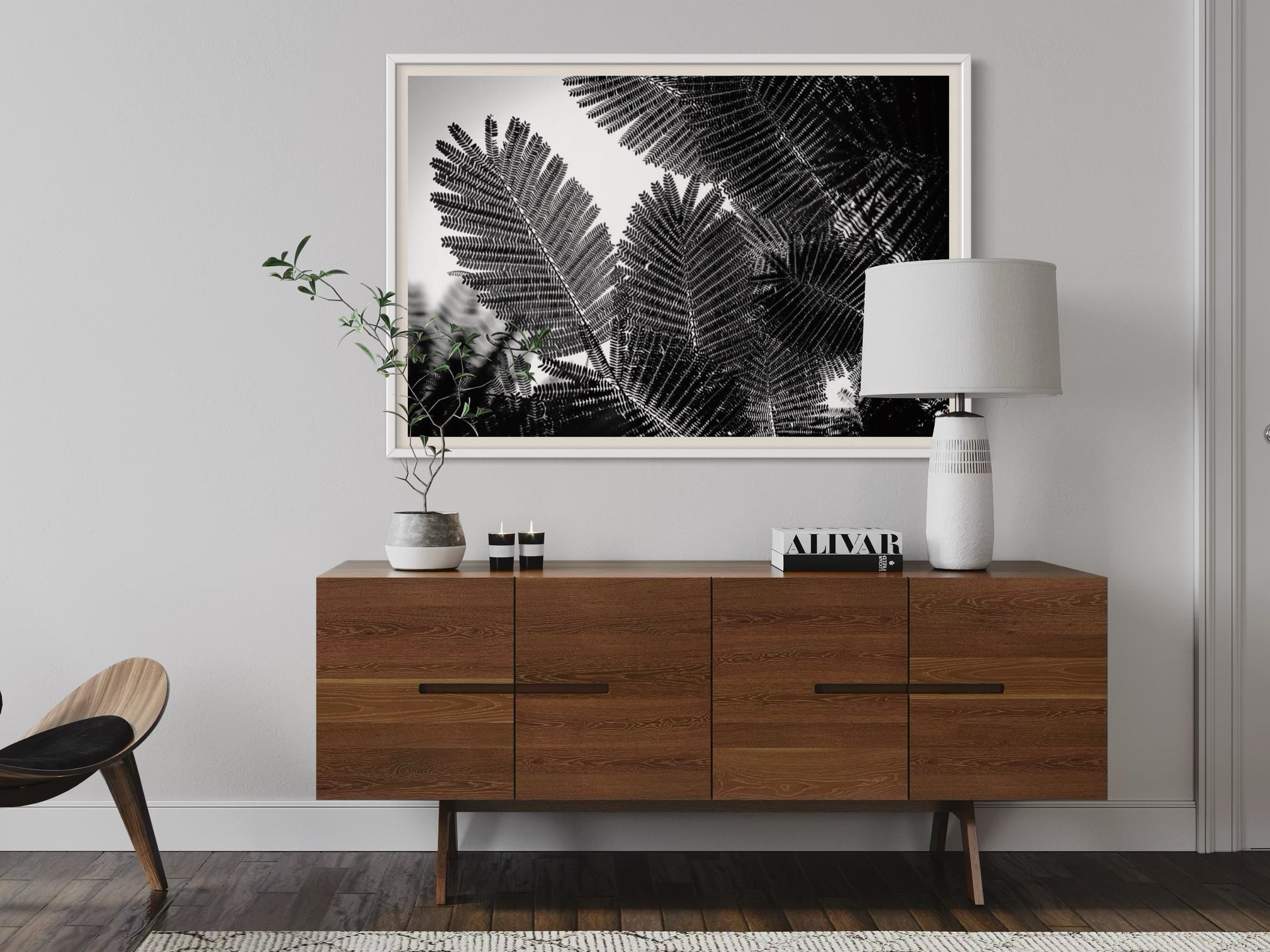 Modern living room with wooden sideboard, lamp, and framed artwork on the wall.
