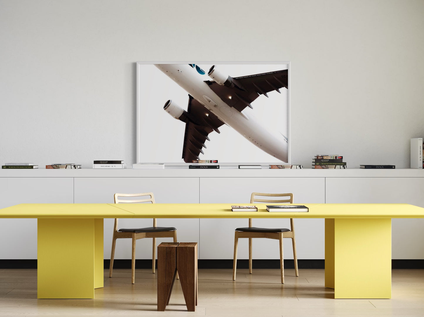 Modern office setup with a yellow table, chairs, and a large abstract painting on the wall.