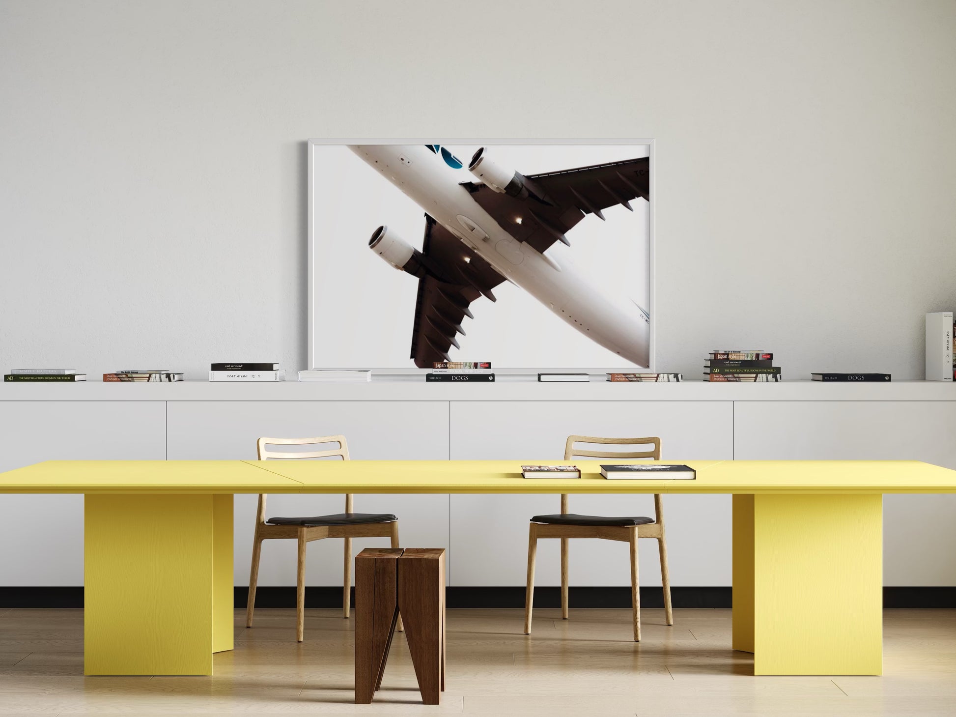 Modern office setup with a yellow table, chairs, and a large abstract painting on the wall.