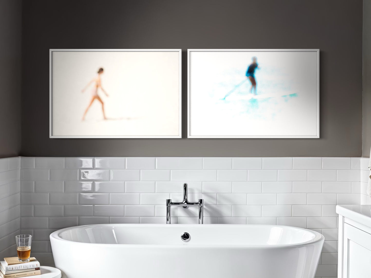 Modern bathroom with a freestanding bathtub, white tiles, and abstract art on the wall.