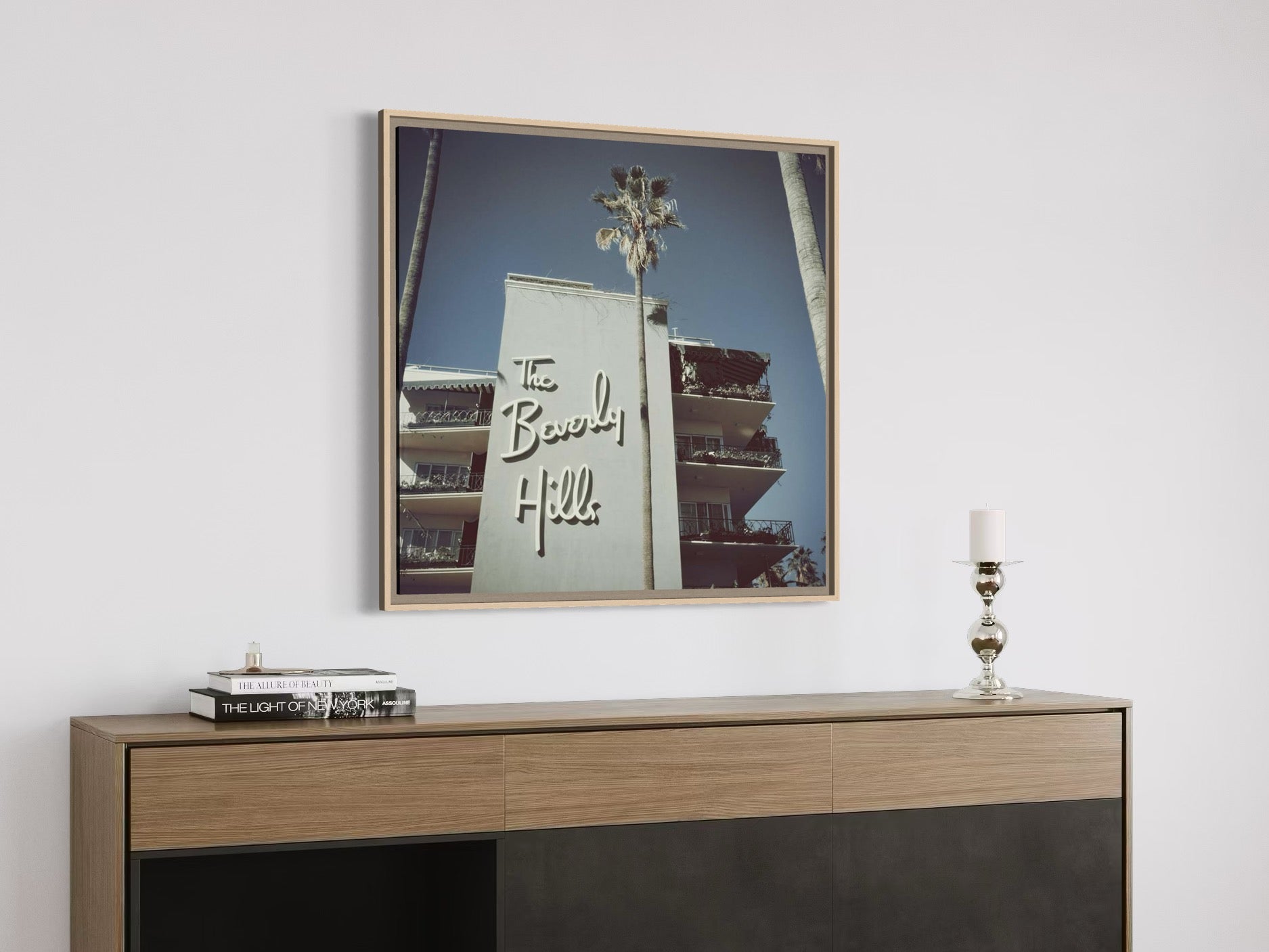 Framed artwork on a wall above a wooden console table with decorative items.