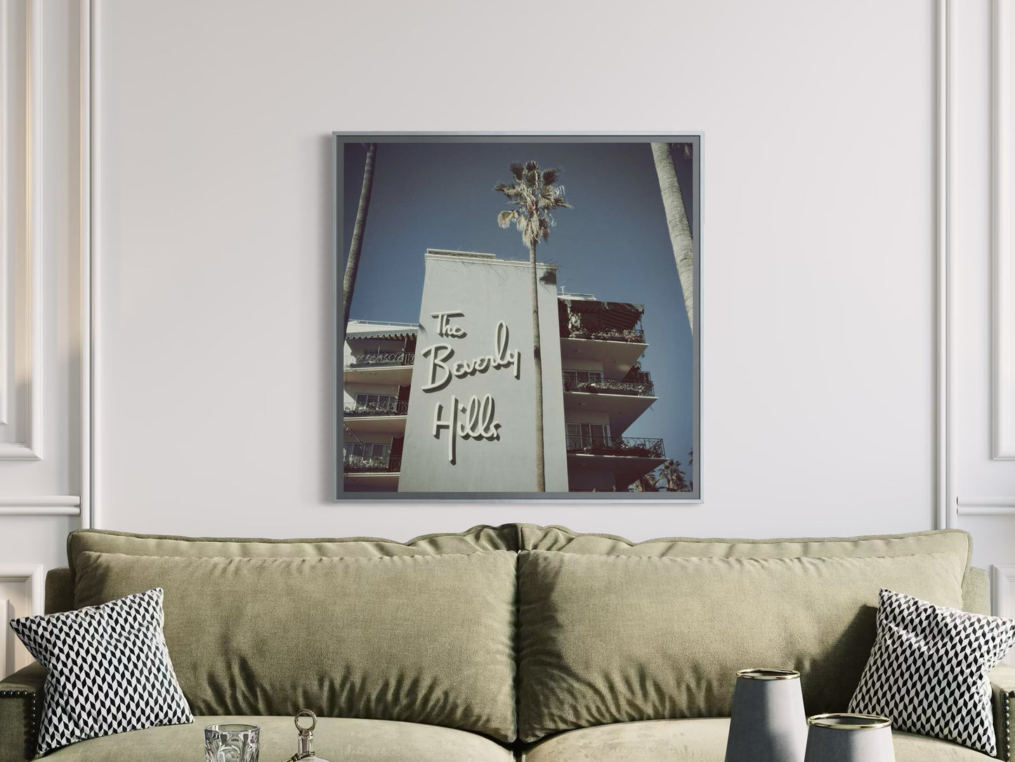 Framed artwork of a building with 'The Beverly Hills' sign above a beige sofa.