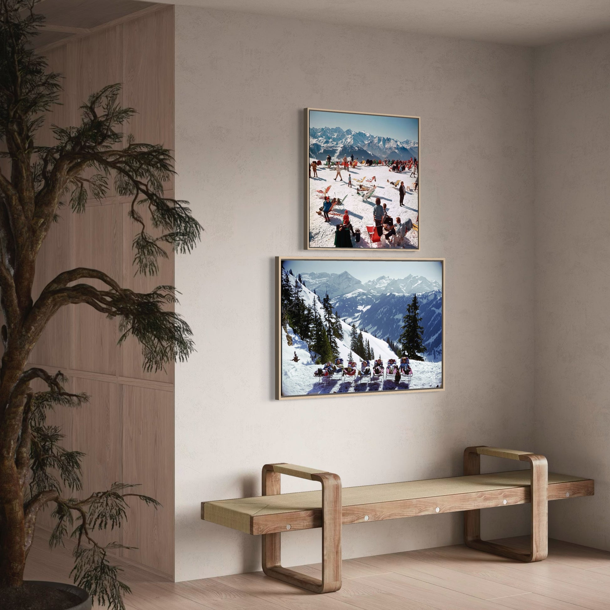 Two framed photographs of snowy mountain scenes on a wall above a wooden bench.