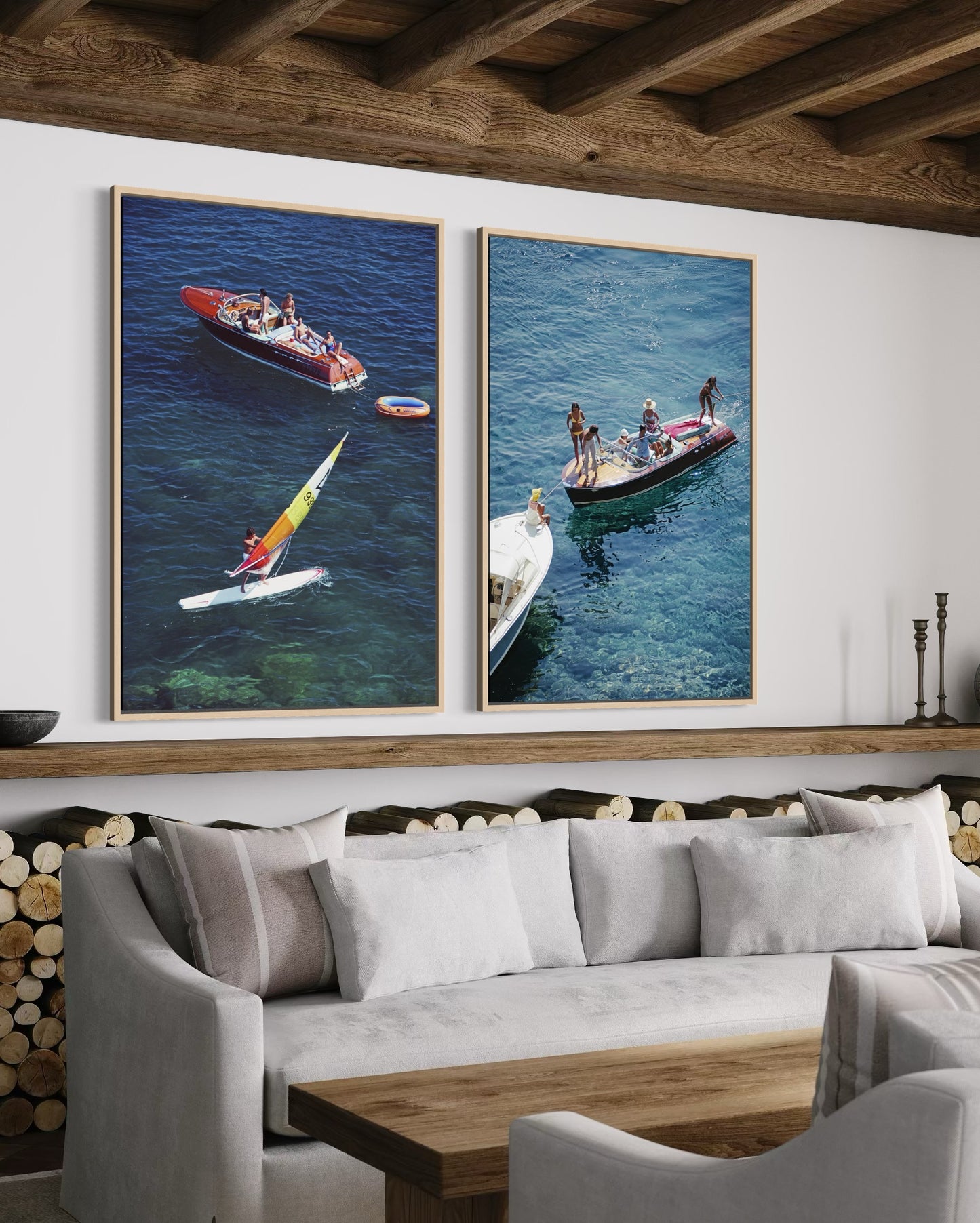 Two framed pictures of people on boats hanging above a sofa in a room with wooden beams.