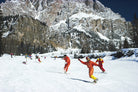 People skiing on a snowy mountain with snow-covered trees and mountains in the background.  The Picturalist Slim Aarons Collection