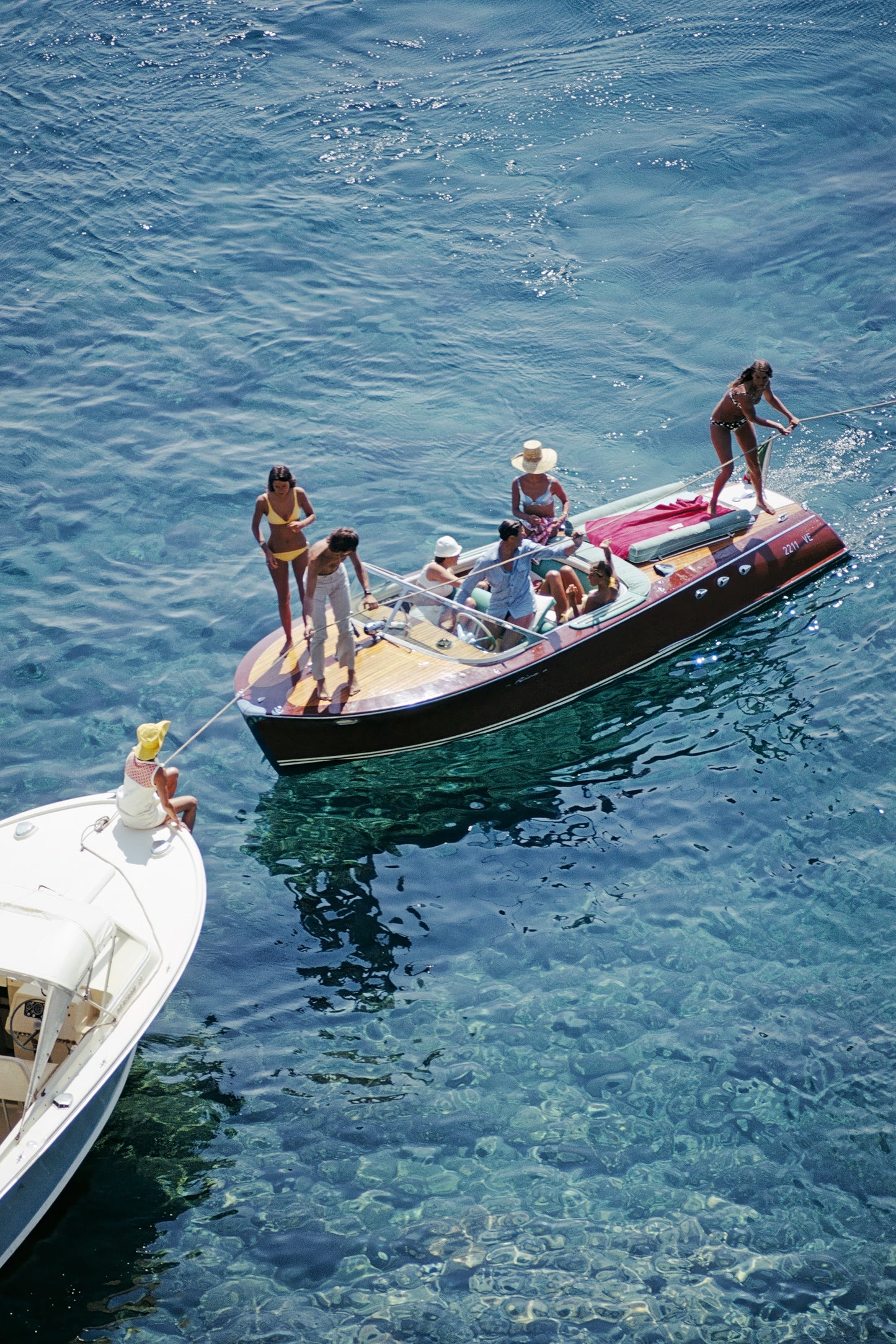 People on a small boat in the water with another boat nearby