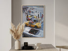 Framed poster of a race car scene on a wall above a table with decorative items.