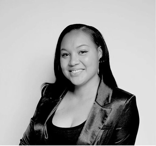 Black and white portrait of a woman wearing a satin jacket against a plain background