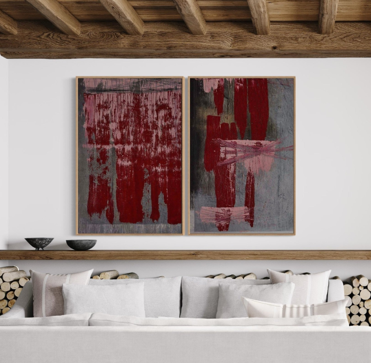 Abstract art pieces on a wall above a sofa with decorative elements.