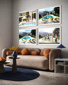 A styled living room interior featuring a beige sofa with orange cushions, a round blue rug, and a side table. Above the sofa, four framed photographic prints depicting poolside scenes are mounted on a light gray wall. The Picturalist Wall Art and Photography for Designed Interiors. Slim Aarons Collection, Poolside. Getty Images Gallery. 