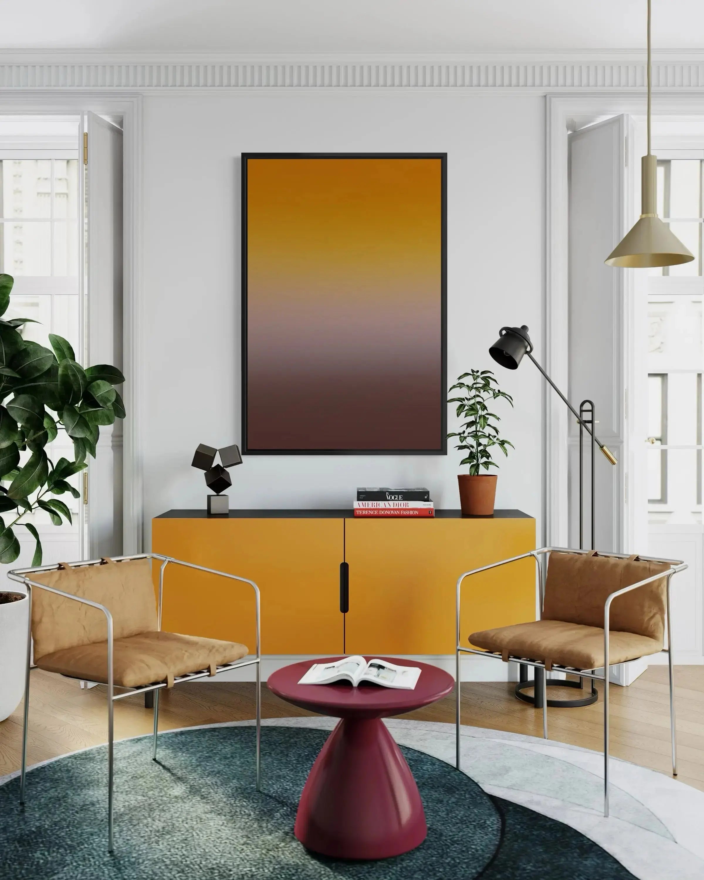 A modern living room scene featuring a large vertical framed art print with a yellow-to-brown gradient, displayed above a bright yellow cabinet. The room includes two brown upholstered armchairs with chrome frames, a small round red coffee table, and a green potted plant.