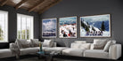 Three framed winter mountain art prints displayed on a dark gray wall above a modern white sectional sofa in a styled living room.