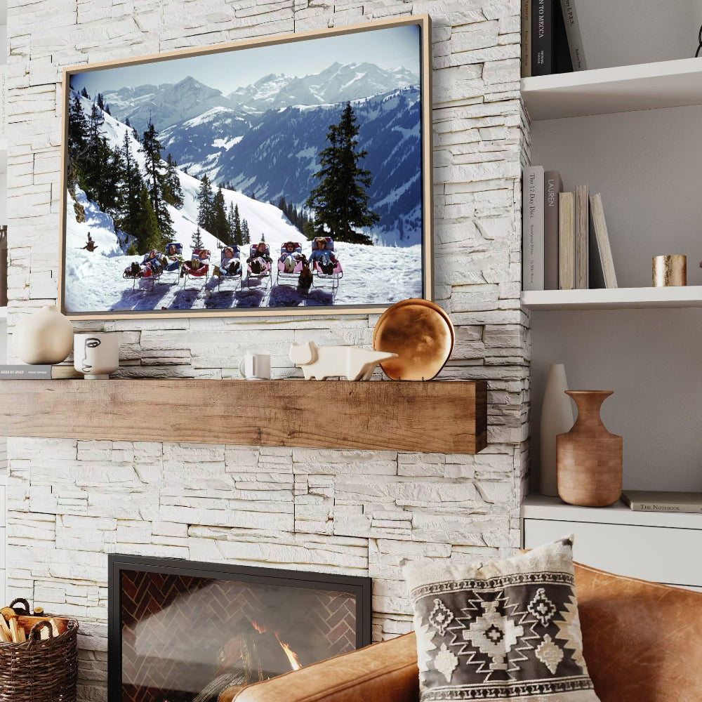 Living room with stone fireplace, TV showing mountain scene, and decorative items.