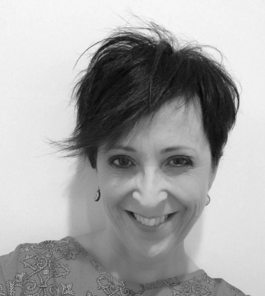 Black and white photo of a person with short hair against a plain background