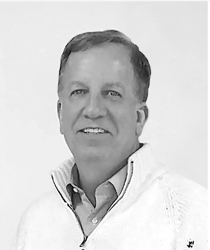 Black and white photo of a man wearing a white sweater with a logo on a light gray background