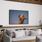 Luminous Cowboy Tale neon cowboy print displayed in a modern living room, designer wall art by The Picturalist.