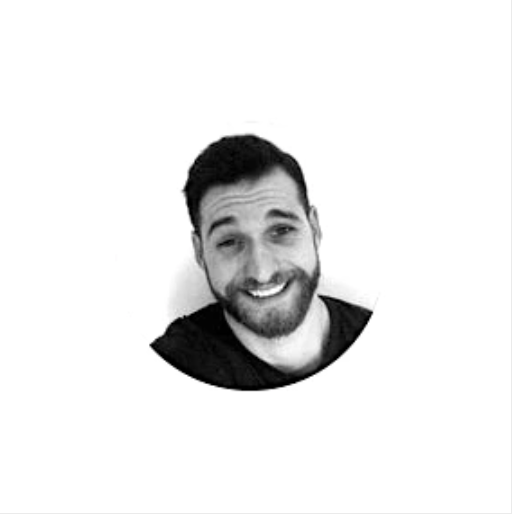 Black and white circular portrait of a smiling person with a beard.