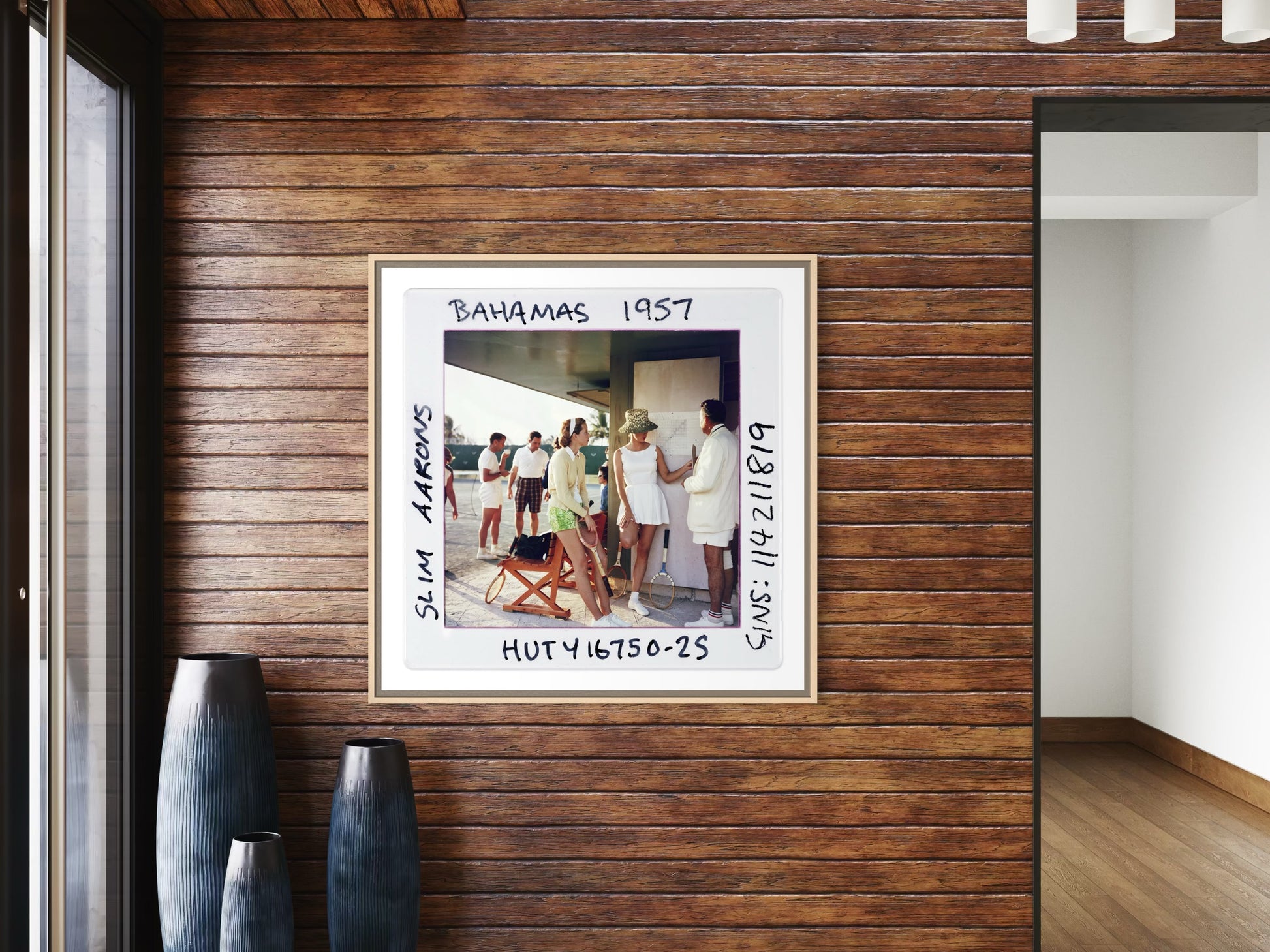 Framed photo of people in a tropical setting on a wooden wall.