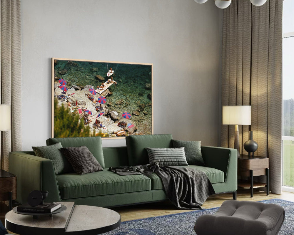 Modern living room with a green sofa, decorative pillows, and a large framed picture on the wall.