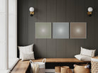 Wall with three color abstract metal prints and a wooden bench with pillows.