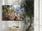 Canvas print of a group of people at a picnic with a scenic background, hanging on a wall with a plant in the foreground.